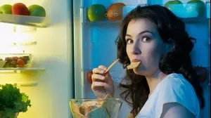 אישה אוכלת ליד המקרר