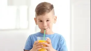 ילד שותה מיץ תפוזים בקשית