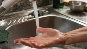 אישה שוטפת את היד תחת מים זורמים בכיור