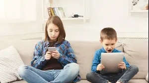 ילד וילדה גולשים בסמארטפון ובטאבלט