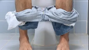 גבר יושב על אסלת השירותים