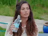אישה שופכת על עצמה בקבוק מים