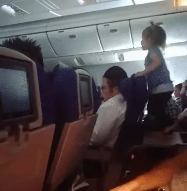 פעוטה קופצת על מגש אוכל במטוס
