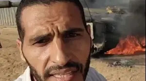 העיתונאי חסן אסליח ליד טנק בוער במתקפת 7 באוקטובר 2023 של חמאס