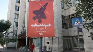 People walk next to a banner, following the Israeli strikes on Iran, in Tehran, Iran, June 15, 2025. Majid Asgaripour/WANA (West Asia News Agency) via REUTERS ATTENTION EDITORS - THIS PICTURE WAS PROVIDED BY A THIRD PARTY.