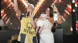 מורן בן אסולין לצד דודו פארוק. עם תינוק ביד וערק ביד השניה