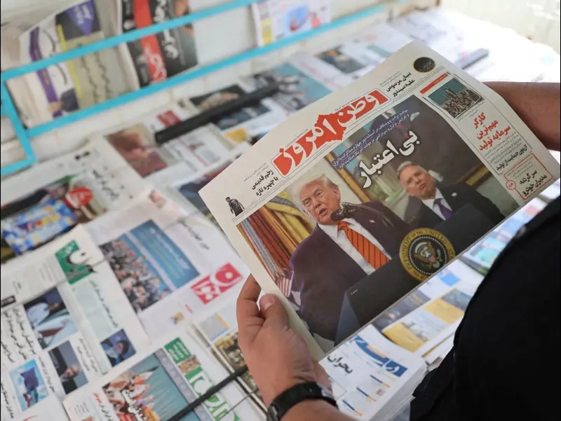 אדם מחזיק עיתון עם תמונה של טראמפ וויטקוף בטהראן, איראן, 11 במאי 2025