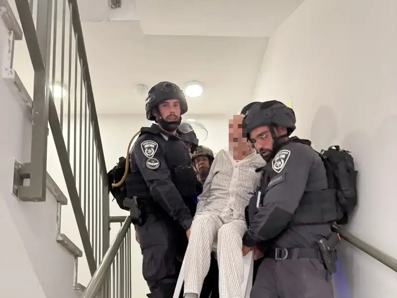 לוחם יחידת מג"ן של ימ"ר דרום מחלץ קשישה מזירת פגיעה מנפילת טיל ששוגר מאיראן, 20 ביוני 2025